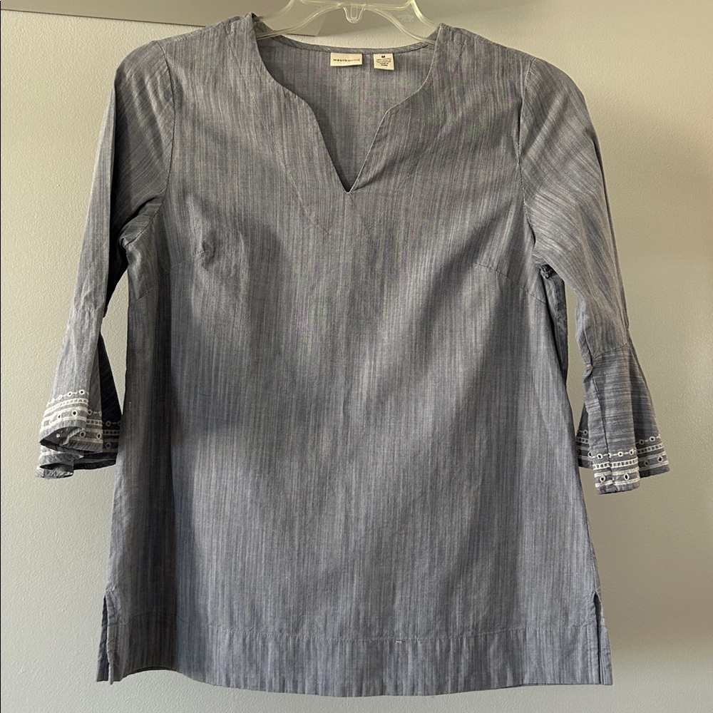 Women’s washed denim v-neck top with 3/4 length eyelet detail on sleeves.